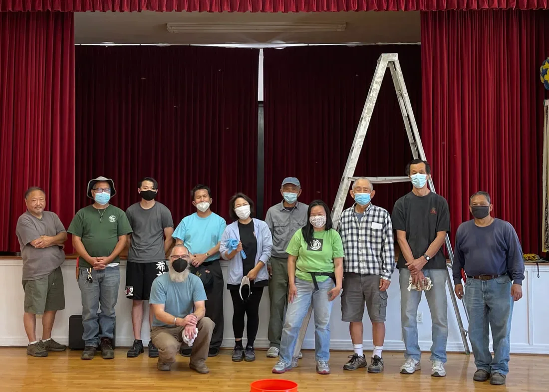 A group gathered in the HJCI Social Hall after caring for the facility.